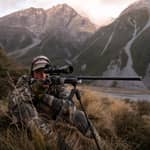 Jägare i kamouflagekläder siktar med gevär monterat på Spartan Springbok bipod i bergsterräng