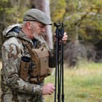 En jägare som hanterar och justerar ett Spartan Springbok Quad skjutstöd ute i skogen.