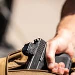 Vortex Defender-CCW slutet rödpunktsikte monterat på en pistol, fotograferat från en ovanifrån- och sidovinkel i hölster
