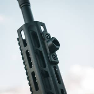 Närbild av en svart Spartan M-Lok adapter monterad på ett gevärs handskydd med M-Lok system.