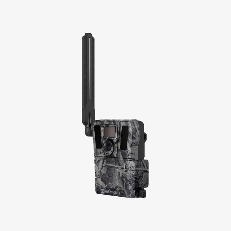 HIKMICRO M15 4G åtelkamera i kamouflagemönster sedd snett från vänster med antennen monterad.