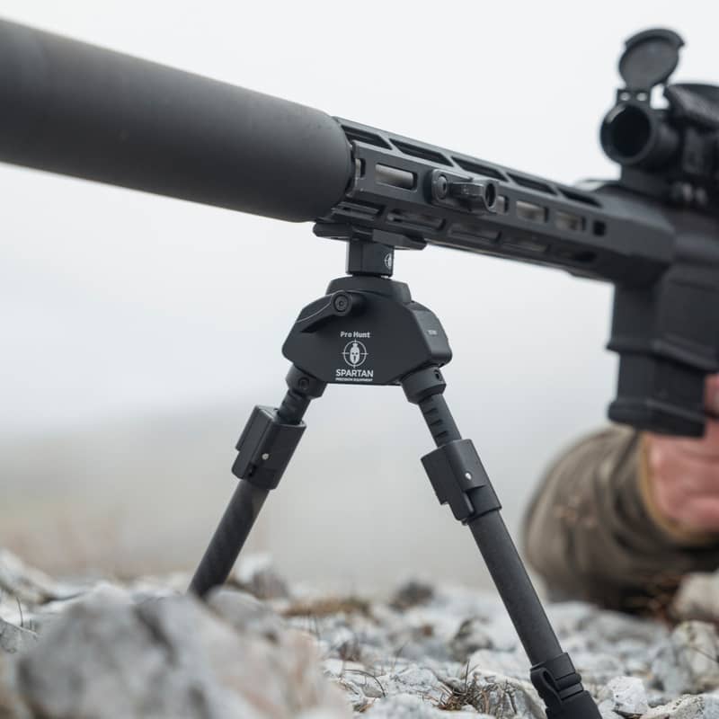 Spartan M-Lok adapter monterad på ett gevär med benstöd i stenig terräng
