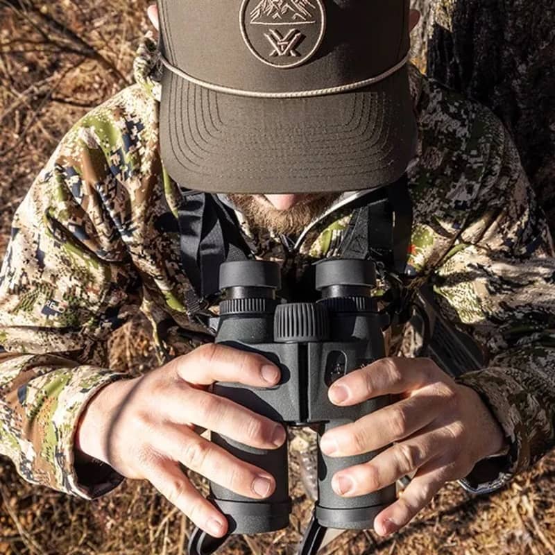 Vortex Ranger HD 3000 10x42 kikare hållen i händerna av en person i kamouflagekläder, sedd ovanifrån